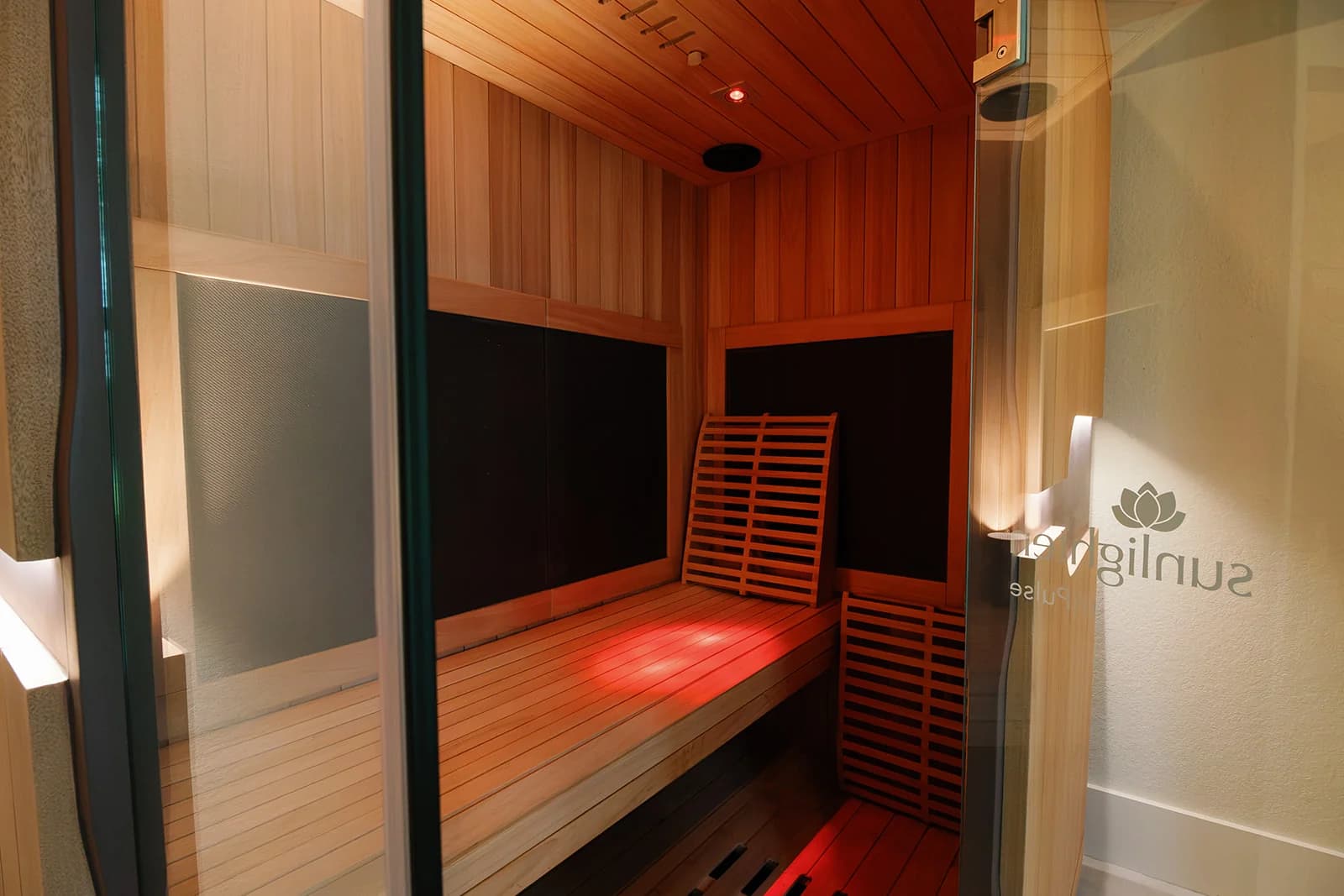 Interior of the infrared sauna at OutRecover, lit with red light